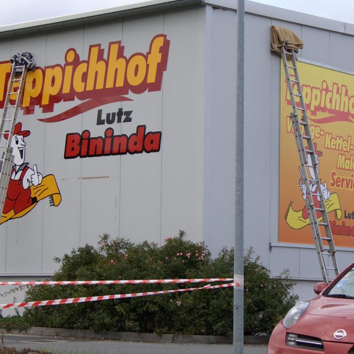 großflächige Fassadenwerbung an einer Hallenwand