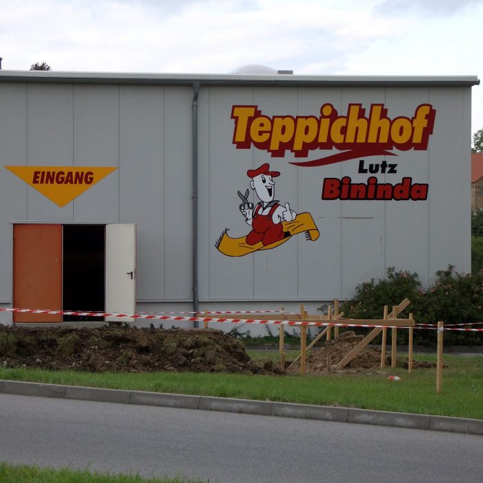 Frontansicht einer großflächigen Fassadenwerbung an einer Hallenwand