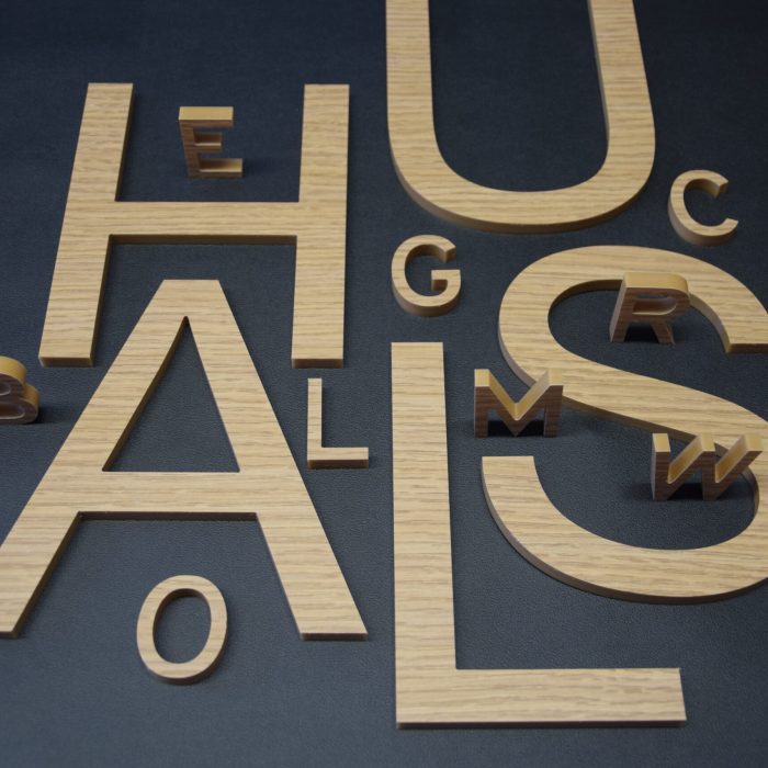 gefräste Buchstaben aus Holz – Strukturfolie auf Acryl