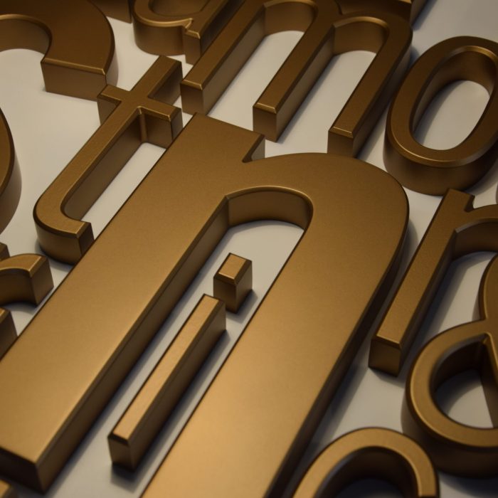 detailaufnahme goldene Buchstaben vor hellem Hintergrund